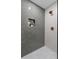 Modern shower with gray tiling, a built-in niche, and decorative gold shower head and faucet at 6456 Wright Ne Rd, Atlanta, GA 30328