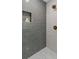 Modern shower with gray tiling, a built-in niche, and decorative gold shower head and faucet at 6456 Wright Ne Rd, Atlanta, GA 30328