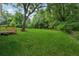 Expansive green backyard featuring a large tree, lawn and a wooden deck, ideal for outdoor activities at 4451 Flat Shoals Pkwy, Decatur, GA 30034
