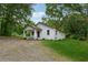 Well-maintained home on a spacious lot with mature trees, showcasing the property's outdoor space at 4451 Flat Shoals Pkwy, Decatur, GA 30034