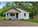 Charming white-painted home with a covered front porch and lush landscaping, offering curb appeal at 4451 Flat Shoals Pkwy, Decatur, GA 30034