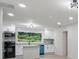 A spacious, bright kitchen with island, white cabinetry, a modern backsplash, and a large garden window at 4451 Flat Shoals Pkwy, Decatur, GA 30034