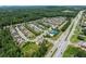 Aerial view of townhouses with a tennis court and highway in the distance at 4458 Dunblane Ave, Sugar Hill, GA 30518