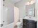 Well-lit bathroom with a tub, shower, and dark vanity at 4458 Dunblane Ave, Sugar Hill, GA 30518