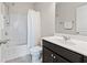Bathroom featuring a bathtub-shower combination, neutral walls, and dark wood vanity with white sink at 4458 Dunblane Ave, Sugar Hill, GA 30518