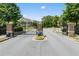 Gated community entrance featuring brick pillars, black iron gate, and well-maintained landscaping for added security at 4458 Dunblane Ave, Sugar Hill, GA 30518