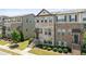 Charming townhome showcasing a mix of brick and stone, a covered porch, and professional landscaping at 4458 Dunblane Ave, Sugar Hill, GA 30518