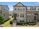 Charming townhome featuring a mix of brick and stone, a covered porch, and professional landscaping at 4458 Dunblane Ave, Sugar Hill, GA 30518