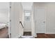 Upstairs hallway with neutral paint, hardwood floors, window, and doors at 4458 Dunblane Ave, Sugar Hill, GA 30518