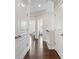 Hallway featuring hardwood floors, neutral paint, and views of office and bedroom through doorways at 4458 Dunblane Ave, Sugar Hill, GA 30518