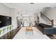 Open concept living room with modern decor, kitchen view, and hardwood flooring at 4458 Dunblane Ave, Sugar Hill, GA 30518