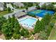 Aerial shot of a community pool and tennis court surrounded by mature trees at 4458 Dunblane Ave, Sugar Hill, GA 30518