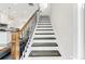 Wooden staircase with white risers and dark wood treads and black metal railing at 4458 Dunblane Ave, Sugar Hill, GA 30518