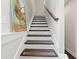 View of the carpeted stairway with wooden handrail and white trim at 4458 Dunblane Ave, Sugar Hill, GA 30518