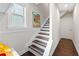 Bright stairway with wood steps and a large window at the landing at 4458 Dunblane Ave, Sugar Hill, GA 30518