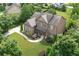 An aerial view of the brick home showcasing its landscaping, driveway, and lush green surroundings at 4547 Meadow Green Nw Ln, Acworth, GA 30101