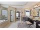 Bathroom featuring double vanities, soaking tub, glass enclosed shower, and neutral tile at 4547 Meadow Green Nw Ln, Acworth, GA 30101