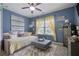 Cozy bedroom features large window with yellow curtains, daybed, ceiling fan, and blue walls at 4547 Meadow Green Nw Ln, Acworth, GA 30101