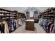 Large walk-in closet with custom shelving, hanging rods, and center island for storage at 4547 Meadow Green Nw Ln, Acworth, GA 30101