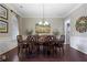 Formal dining room featuring a wooden table set for six, wainscoting, and chandelier at 4547 Meadow Green Nw Ln, Acworth, GA 30101