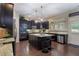 Spacious kitchen features dark cabinets, granite countertops, stainless steel appliances, and a center island with bar stool seating at 4547 Meadow Green Nw Ln, Acworth, GA 30101