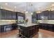 Bright kitchen features dark cabinetry, granite countertops, stainless steel appliances, and a center island with bar stool seating at 4547 Meadow Green Nw Ln, Acworth, GA 30101