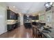Wide angle view of kitchen with dark cabinets, granite countertops, stainless steel appliances, and center island with seating at 4547 Meadow Green Nw Ln, Acworth, GA 30101