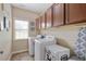 Functional laundry room features washer, dryer, storage cabinets, and natural light at 4547 Meadow Green Nw Ln, Acworth, GA 30101