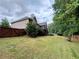 Landscaped backyard featuring a privacy fence and mature trees at 237 Shockley Way, Dallas, GA 30157