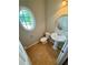 Powder room with pedestal sink, toilet, and decorative oval window at 237 Shockley Way, Dallas, GA 30157