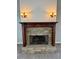 Close-up of a stone fireplace with a decorative wood mantle and sconces at 237 Shockley Way, Dallas, GA 30157