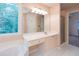 Bathroom with a large window, double sink vanity, garden tub, and a glass shower at 5287 Wild Indigo Way, Acworth, GA 30102