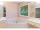 Bathroom showcasing a large soaking tub next to a vanity and window at 5287 Wild Indigo Way, Acworth, GA 30102