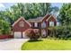 Traditional brick home showcasing an attached two-car garage and meticulously maintained front yard at 5287 Wild Indigo Way, Acworth, GA 30102