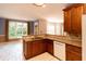 Bright kitchen featuring granite countertops, wood cabinets, white tile flooring, and large windows, creating a welcoming and functional space at 5287 Wild Indigo Way, Acworth, GA 30102