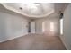 Spacious bedroom with neutral carpet, tray ceiling, arched doorway, and ample natural light from windows, providing comfort and style at 5287 Wild Indigo Way, Acworth, GA 30102