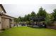 Expansive backyard featuring a stone patio, dining space, and lush greenery for outdoor entertaining and relaxation at 552 Warrenton Run Dr, Sugar Hill, GA 30518