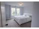 Cozy bedroom with a decorative bed and two windows with lovely curtains at 552 Warrenton Run Dr, Sugar Hill, GA 30518
