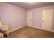 Cozy bedroom with neutral carpet, white trim, and two doors at 552 Warrenton Run Dr, Sugar Hill, GA 30518