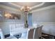 Elegant dining room featuring a stunning chandelier, hardwood floors, and white furniture at 552 Warrenton Run Dr, Sugar Hill, GA 30518