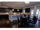 Kitchen and dining area featuring dark cabinetry, granite counters, and modern pendant lighting at 552 Warrenton Run Dr, Sugar Hill, GA 30518