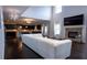 Open-concept living room with a white sectional sofa, fireplace, and a view of the kitchen at 552 Warrenton Run Dr, Sugar Hill, GA 30518