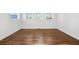 Bright bedroom featuring white walls, trim, three windows and hardwood floors at 1092 Donnelly Sw Ave, Atlanta, GA 30310