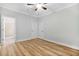 Bedroom with wood-look floors, ceiling fan, and white doors leading to bathroom at 1283 Mercer, East Point, GA 30344