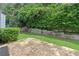 Backyard view of stone patio, lush green lawn, fence and bushes at 1609 Vinery Se Ln, Mableton, GA 30126