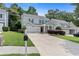 Inviting two-story home featuring a lush green lawn, mature trees, and a long driveway at 1609 Vinery Se Ln, Mableton, GA 30126
