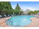 Community swimming pool with lounge chairs, umbrellas and landscaped surroundings at 1609 Vinery Se Ln, Mableton, GA 30126