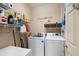 Bright laundry room featuring white washer and dryer, shelving, and storage baskets for organized convenience at 325 Harris Loop, Dallas, GA 30157
