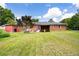 Back exterior of a charming red brick house showcasing a well-manicured lawn at 1191 S Burnt Hickory Rd, Douglasville, GA 30134