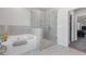 Bathroom showcasing a tub and a separate glass-enclosed shower with tile surround at 1784 Treymire Ct, Stone Mountain, GA 30088